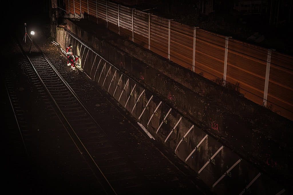 Inspektion von Eisenbahnanlagen bei Nacht mit Sicherheitszaun